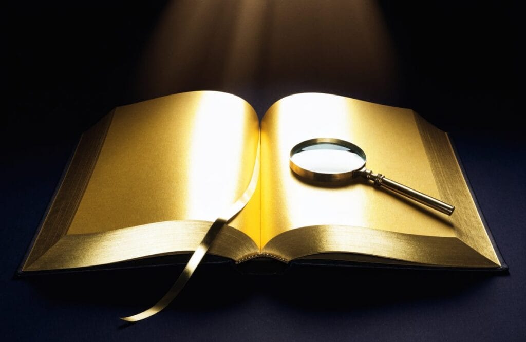 An open hardbound law volume with gilded page edges and a brass magnifying glass resting on it, representing the statutes and judgments behind CLAT legal reasoning questions.
