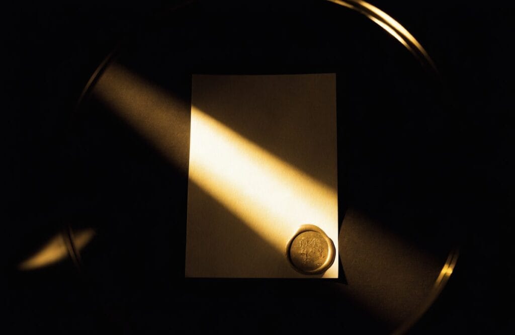 A single sealed document under a narrow shaft of light with a gold wax seal, representing the official CLAT sample paper held behind the Consortium registration login.